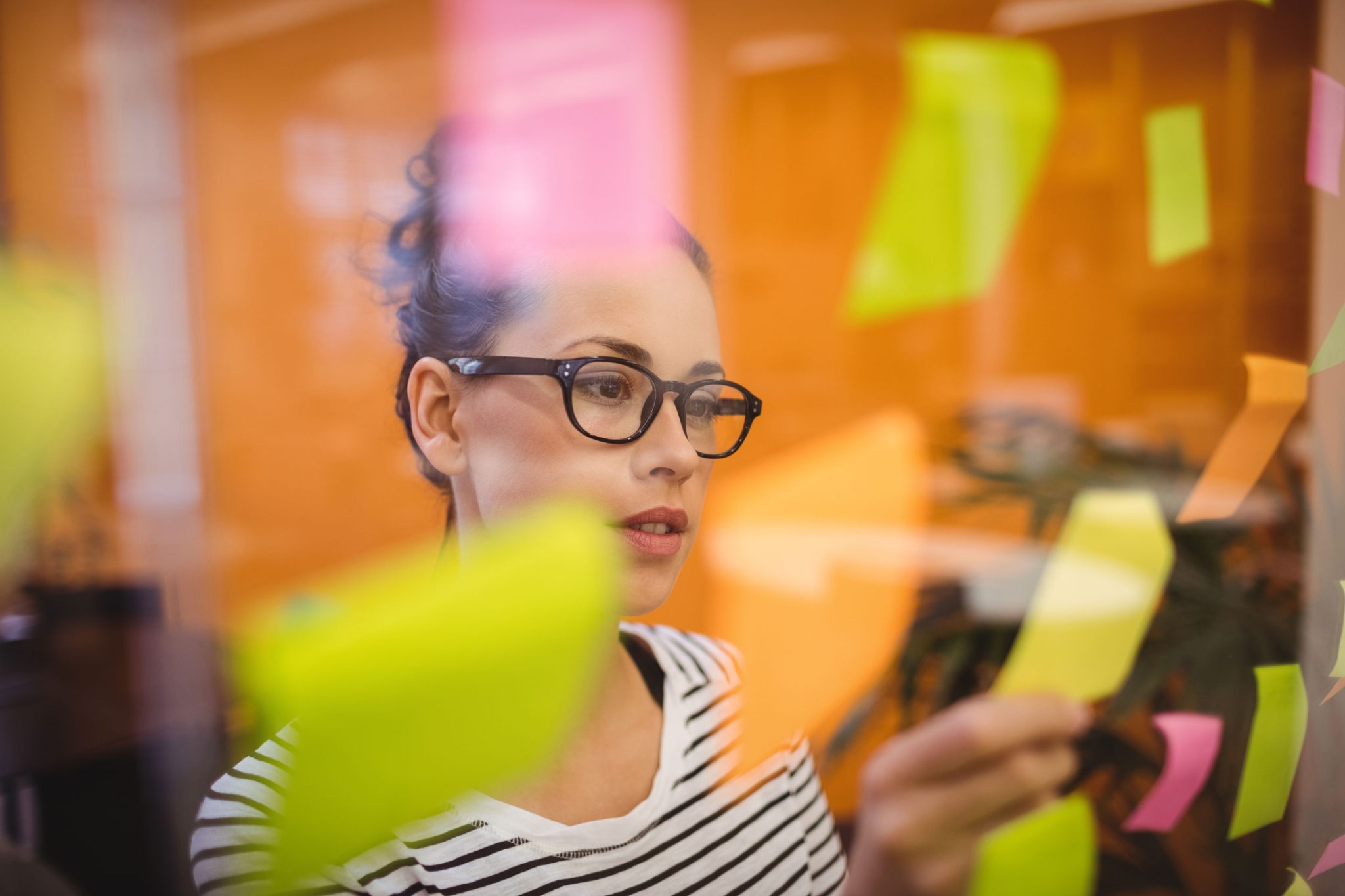 female executive reading sticky notes scaled - A Arte do Storytelling na Odontologia: Conectando-se com Seus Pacientes de Forma Memorável